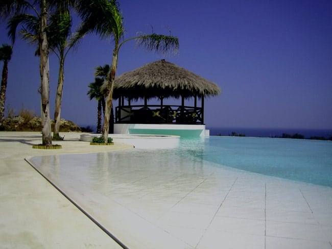 Mixed overflow pool combining infinity edge and perimeter overflow with tropical setting — Morana Water Design