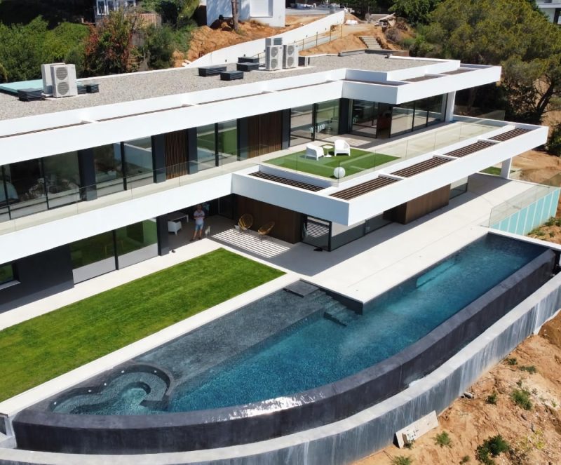 Modern luxury villa with an infinity pool and built-in jacuzzi overlooking a scenic hillside