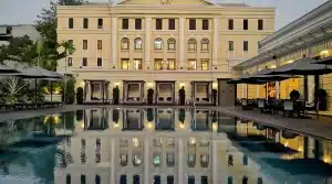 Zero-edge pool with perfect mirror reflection at the historic Strand Hotel courtyard in Yangon, Myanmar, showing colonial architecture