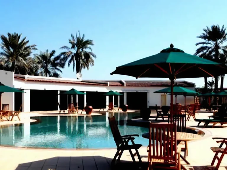 View of the custom-designed zero-edge infinity pool in Bahrain, with sun loungers, palm trees and poolside guest area