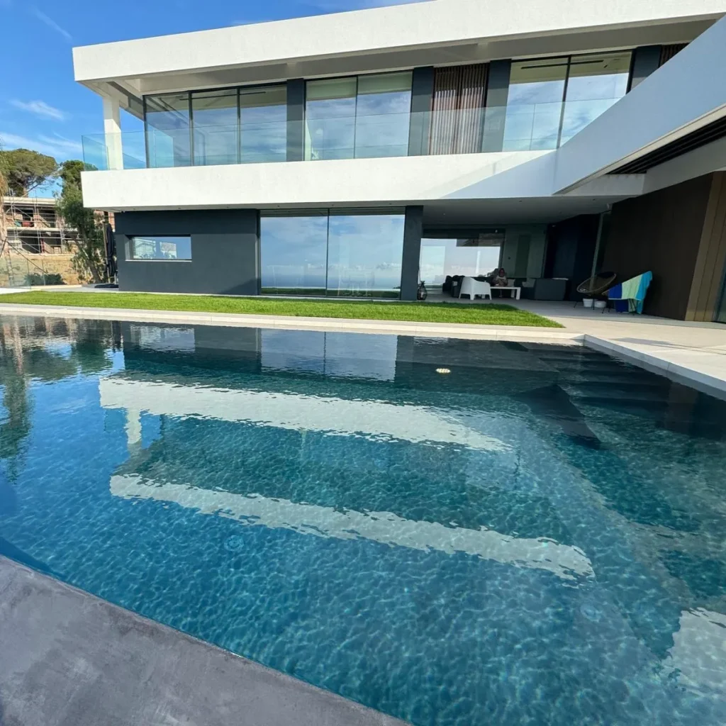 View of the negative pool reflecting the villa’s modern architecture