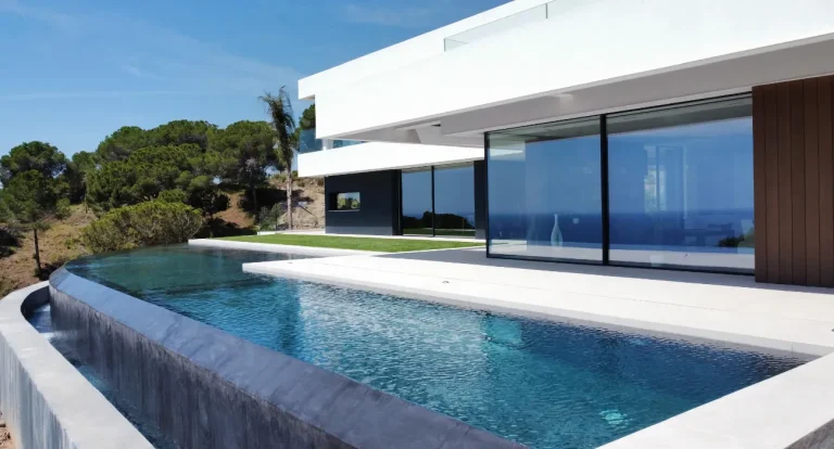 Side view of the infinity edge pool reflecting the modern house
