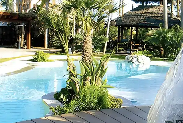 Bespoke Balinese-style infinity pool in Marbella with wooden bridge, tropical plants, and pavilion