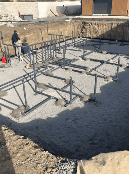 Installation of bottom pipes for water circulation before pouring the concrete slab of an infinity pool