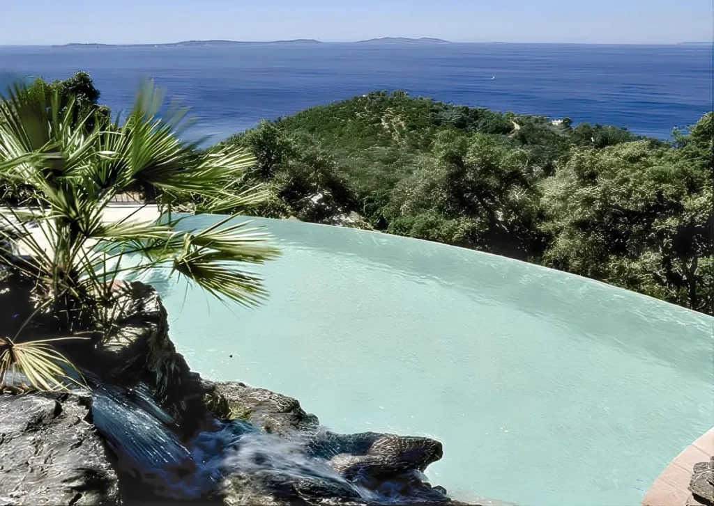 Infinity edge pool with water cascading over the edge towards the sea — Morana Water Design