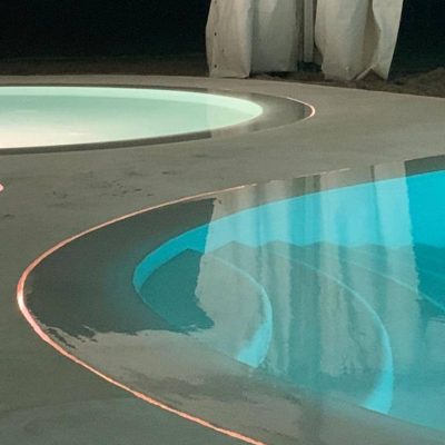 Zero edge pool with perimeter overflow and LED slot lighting.